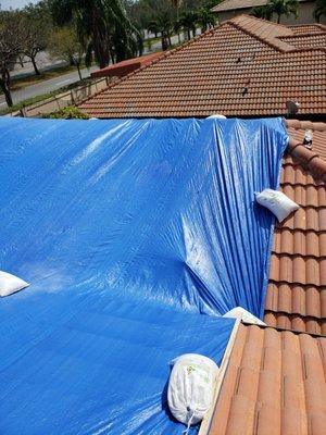 Tarp on the roof of a house to prevent leaking.