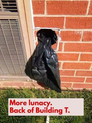 Exhaust fan stuffed with a rag and then a black plastic bag over it. How lazy can you be to not just put a proper cover over the area?