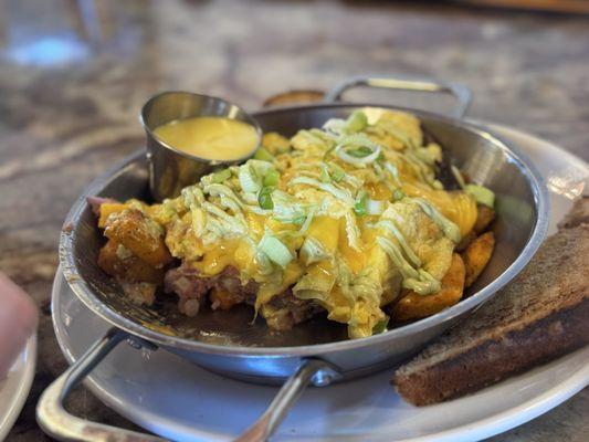 Spiked Hash: House made corn beef hash with skillet potatoes cream and hollandaise sauce w/ scrambled eggs