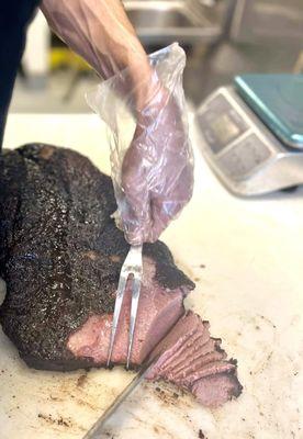 Slicing mouthwatering brisket at Texas Star BBQ, tender and juicy. Come taste the smoky perfection! Texas BBQ Brisket Slicing BBQ Ribs
