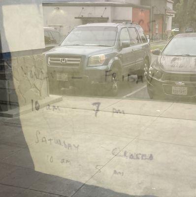 Handwritten sign showing new operating hours.