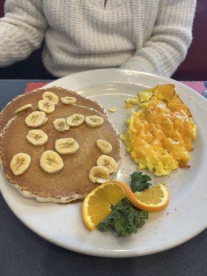 Pancakes with bananas and cheesy scrambled eggs.