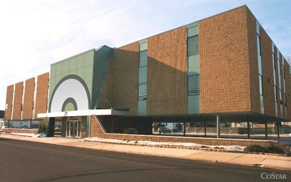 Large professional office building with large parking lot.