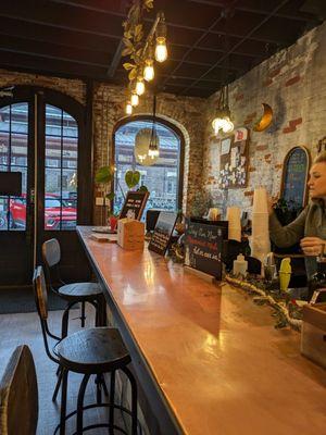 Awesome vibes in this shop set in a historic building with large arched windows, exposed brick, long copper bar top with comfy stools.