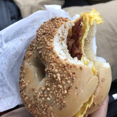 Toasted garlic bagel with scrambled eggs, bacon & cheese