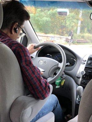 Driver on Facebook while driving.