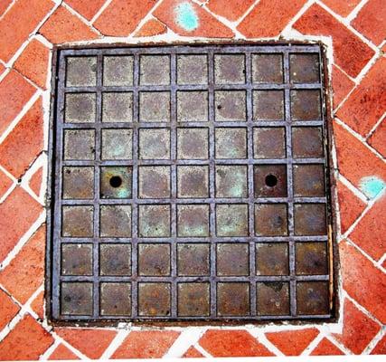 a metal cover on the sidewalk outside