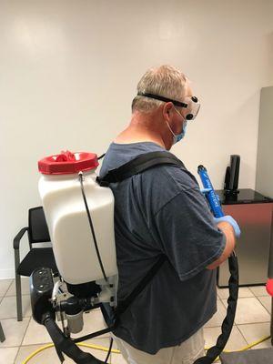 Professional electrostatic disinfection being applied to office surfaces