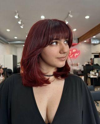 Cherry red full color, with layered haircut and bangs.