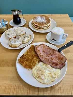 Classic American Breakfast with a side of biscuits and gravy and a cappuccino.