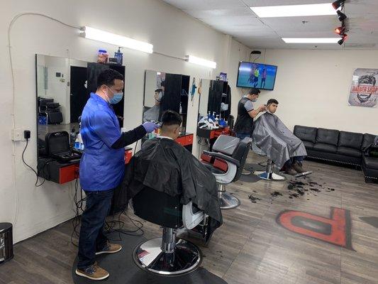 Beto "el barber" (left) cutting hair along with his co worker/brother.