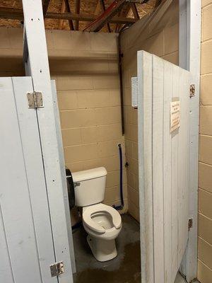 Toilets share an incomplete wall with the other areas. Mens, womens, showers, laundry, utilities