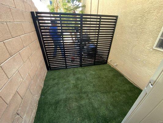Side yard dog enclosure with gate.