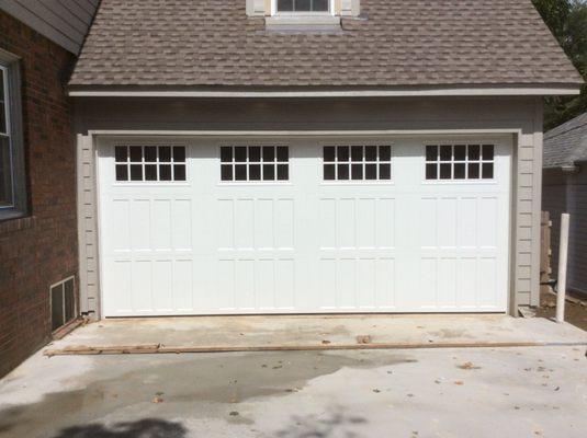 Residential Garage Door installation in Edmond - Recessed Panel Design in white featuring a top row of Moonlight windows.