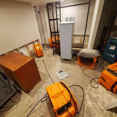 Flooring and walls removed along with a few of the fans used to dry the space and the studs