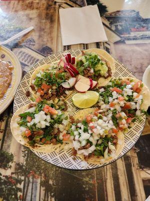 A variety of tacos, al pastor and asada