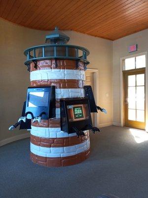 Video game center in the shape of a light house for the kids to enjoy while waiting.