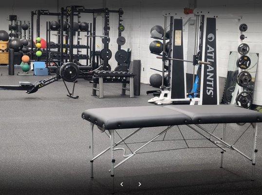 Stretching table with strength equipment in background