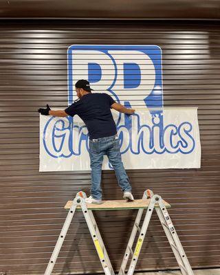 Carefully applying graphics to our storefront!