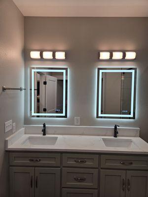 Installed mirrors and towel rack, and moved an outlet as well as sheetrock repair and painting.