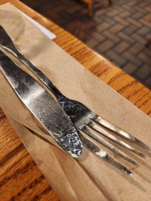 Dirty utensils that were inside sleeve that arrive at table from waitress