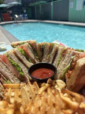 Turkey club and waffle fries poolside