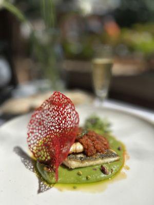 Mediterranean Flame Branzino.
 Grilled branzino topped with smoky fire-roasted tomato and pepper sauce, served over green potato puree with