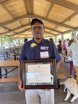 Our Executive Director, Mr. John Smith, with his Educator of the Year award for 2022.