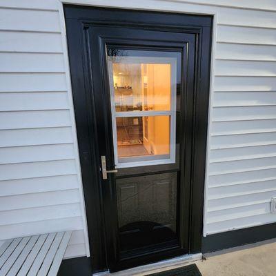 Beautiful self storing exterior steel door with single hung storm door.