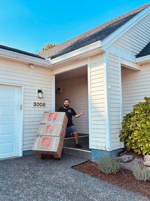Happy mover bringing boxes inside a new home.