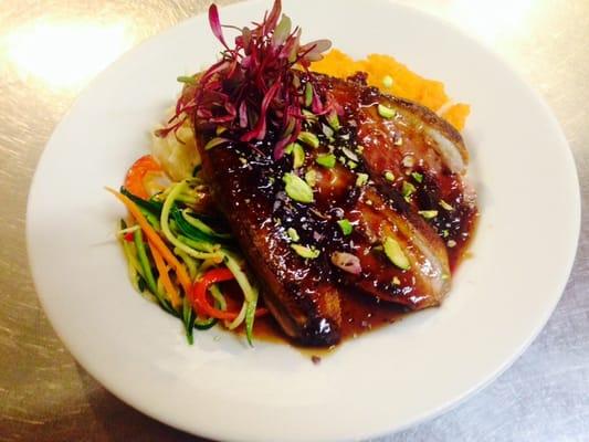 Panseared duck breast with a cranberry gastrique and pistachios