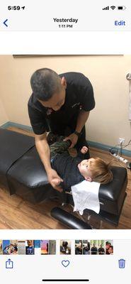 Dr. Mike treating a young boy for back pain