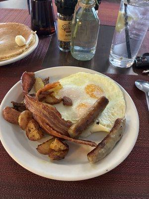 Over cooked eggs and everything cold potatoes, sausage, bacon and a pancake.