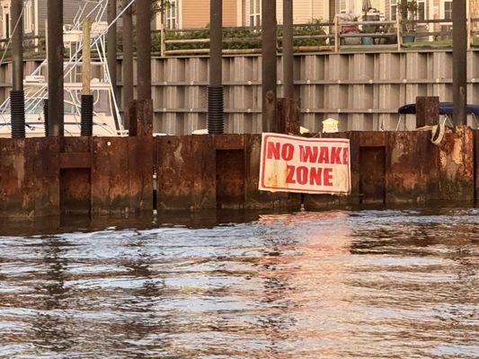 No wake banner on marina steel wall.