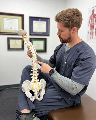 Dr. James Fraser - Chiropractor showing patient vertebra to be adjusted in Basalt doctor's office, Spine Spot Chiropractic in Willits.