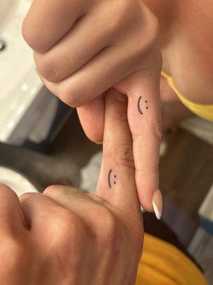 Smiley face tattoo on our fingers
