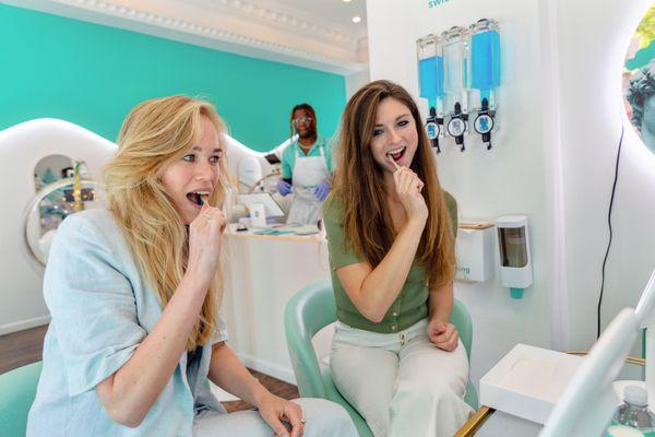 Customers brushing their teeth prior to their whitening treatment.