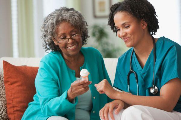 Nurse explaining medication to an elderly woman.