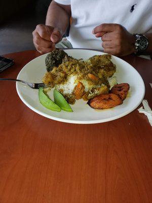 Curry chicken over rice plantains and spinach with avocado.