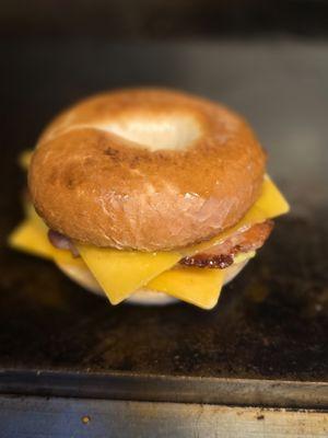 Plain Bagel breakfast sandwich with cheese, and bacon.