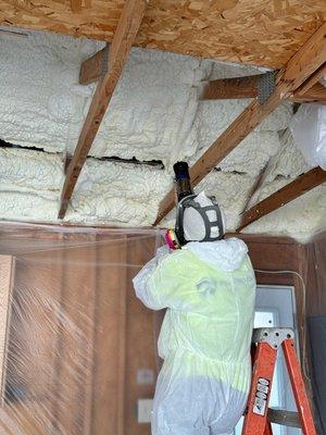 Spray foaming a residential garage with Open Cell Spray foam.