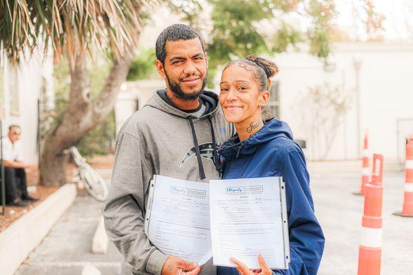 Two IDignity clients smile with their newly received identification documentation.