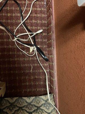 Crumbs, dirt and debris behind first nightstand