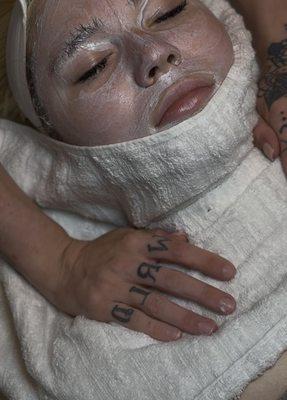 Warm towel applied to face to remove mask