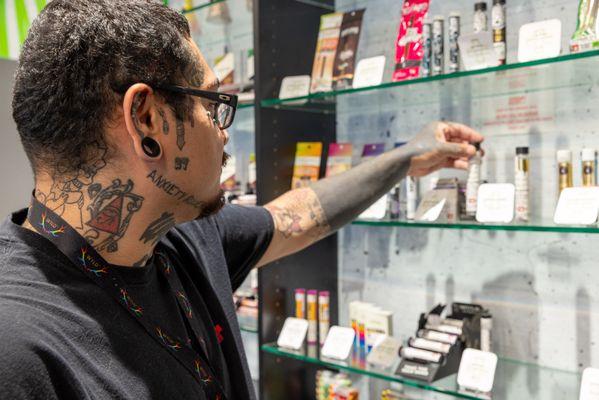 Budtender assisting a customer with product recommendations--helpful and knowledgeable.