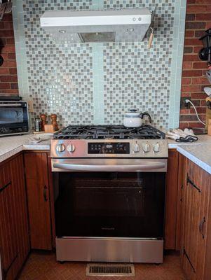 New range went into the old spot perfectly. The flat top range makes the tile backdrop look like a waterfall.