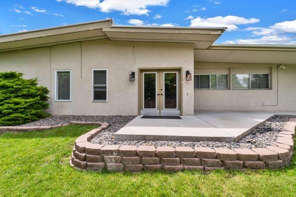 Single-story senior living community with a welcoming entrance, clean landscaping, and a peaceful, home-like exterior under blue skies.
