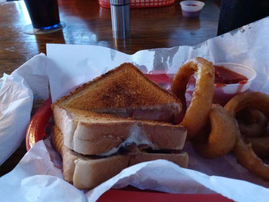 Adult grilled cheese with bacon jam and onion rings. Delicious.