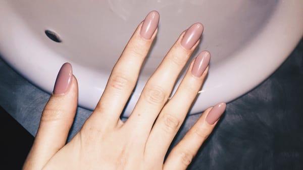 Long almond shaped acrylic nails with a neutral gel polish