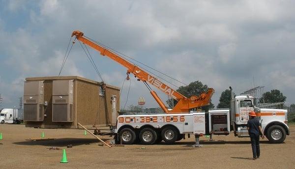 Lifting a cell phone building for a load shift from one flat bed to another.